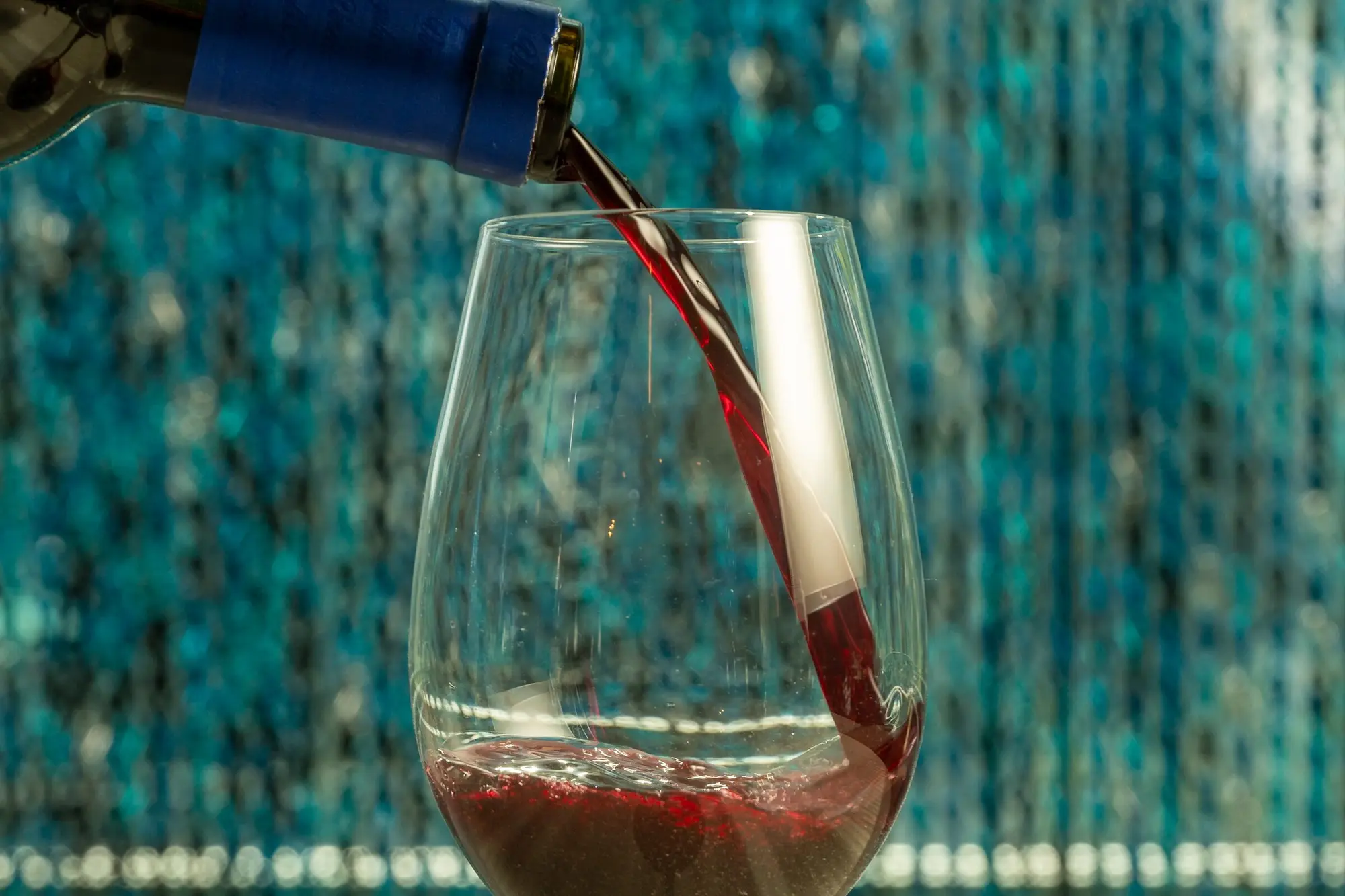 Sirviendo una copa de vino tinto